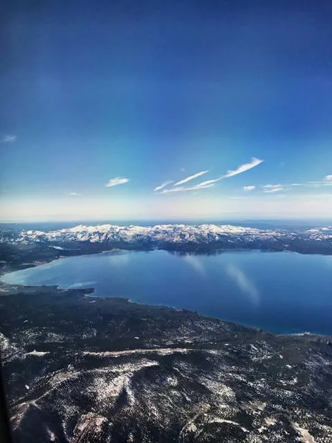 A plane flies over Lake Tahoe in the winter. 