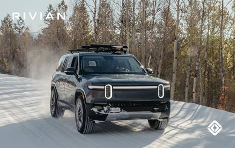 Rivian driving through the snow using Snow Mode