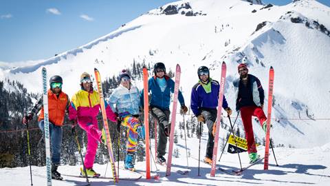 Skiers stand together with one ski up on mountain at Palisades. 