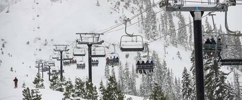 Guests riding up the KT-22 Chairlift at Palisades Tahoe on a snow day. 