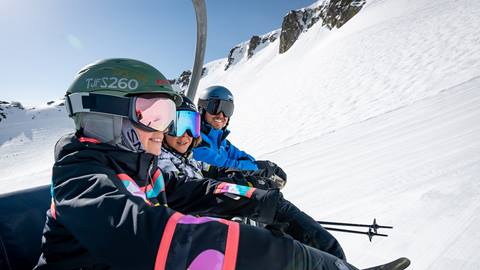 Kids in ski lesson riding a chairlift.