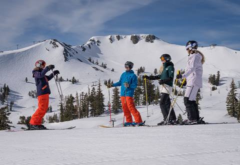 Ski instructor teaching a group of 3 skiiers at Palisades Tahoe.