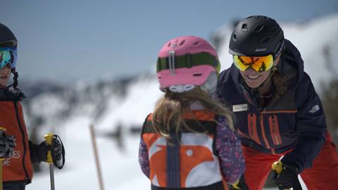 A mountain sports school instructor teaches children how to ski at Palisades Tahoe. 