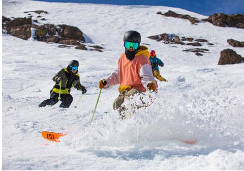 Three spring skiers in bright colors