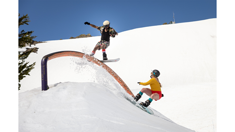 Spring skiing shot of two snowboarders playing in the park.. 