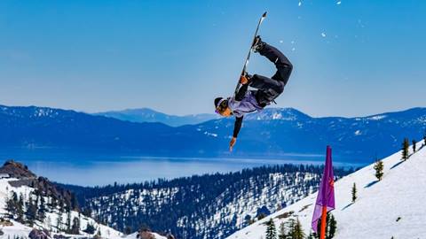 Snowboarder flipping in the terrain park at Palisades Tahoe. 