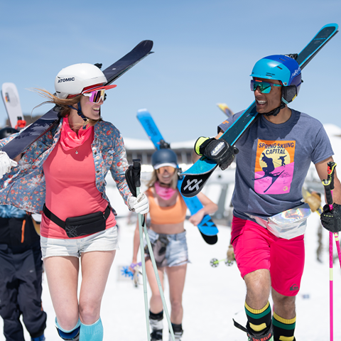 Group of smiling skiers walking on snow