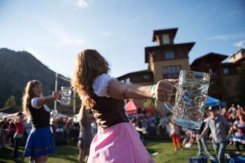 Women in dirndls participate in a stein holding contest at Oktoberfest.