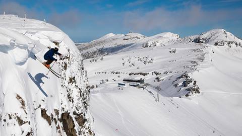 Skier launching off the Palisades at Olympic Valley, Lake Tahoe