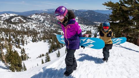 Young snowboarders hiking on a spring day at Olympic Valley