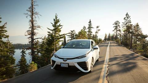 Toyota driving along the road next to Lake Tahoe and pine trees 