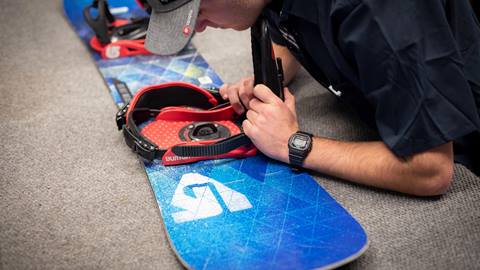 Employee adjusting a Snowboard at the Demo & Rental Shop in Squaw Valley